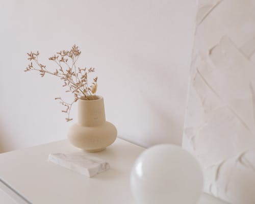 Brown Ceramic Vase With White Flowers on White Table