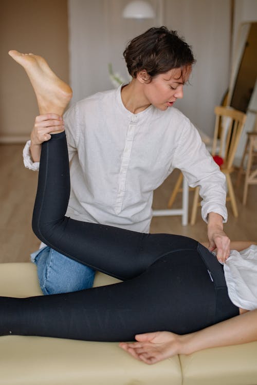 Free A Woman Holding a Person's Leg Stock Photo