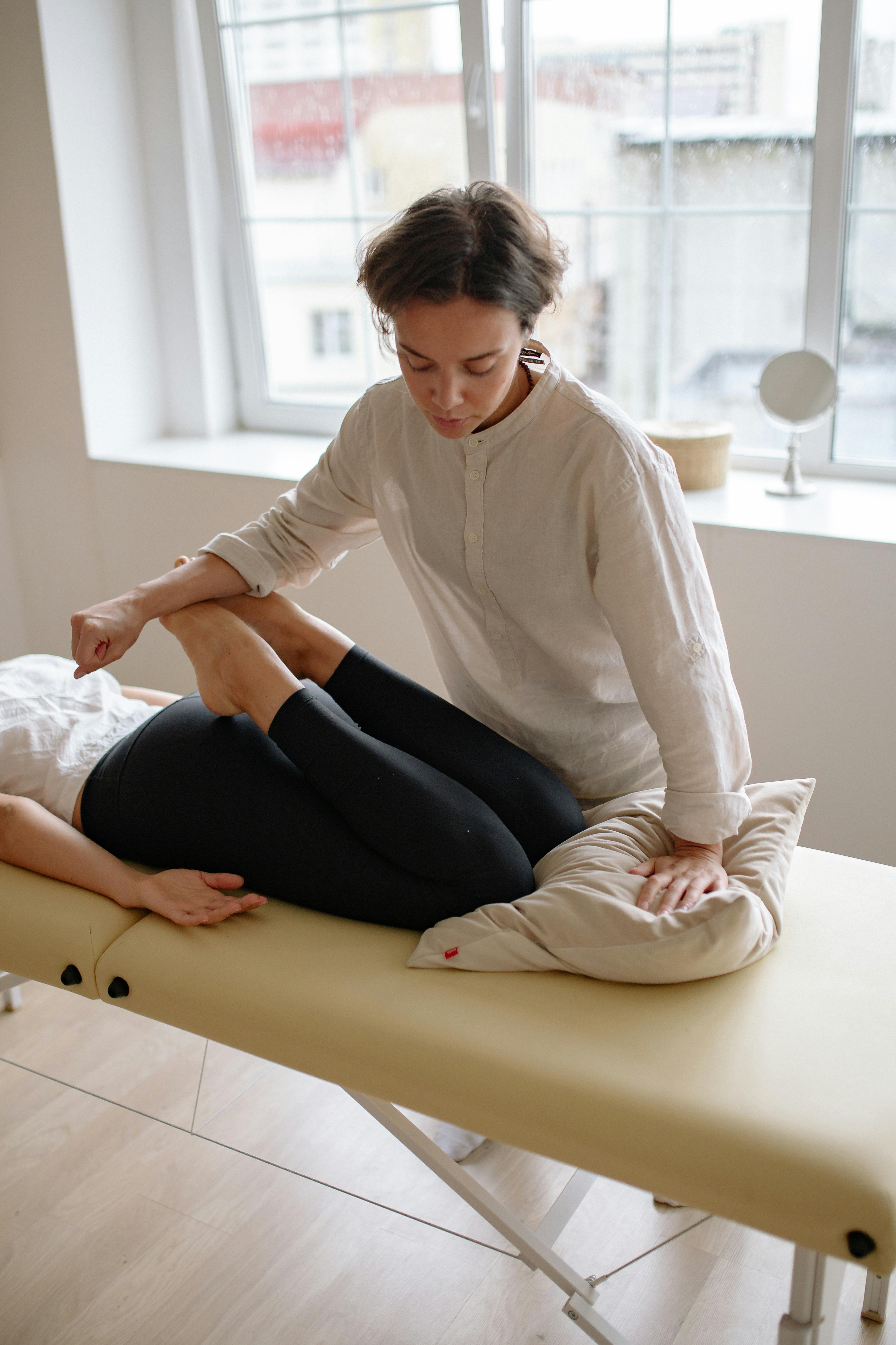 a therapist pressing on a woman s legs