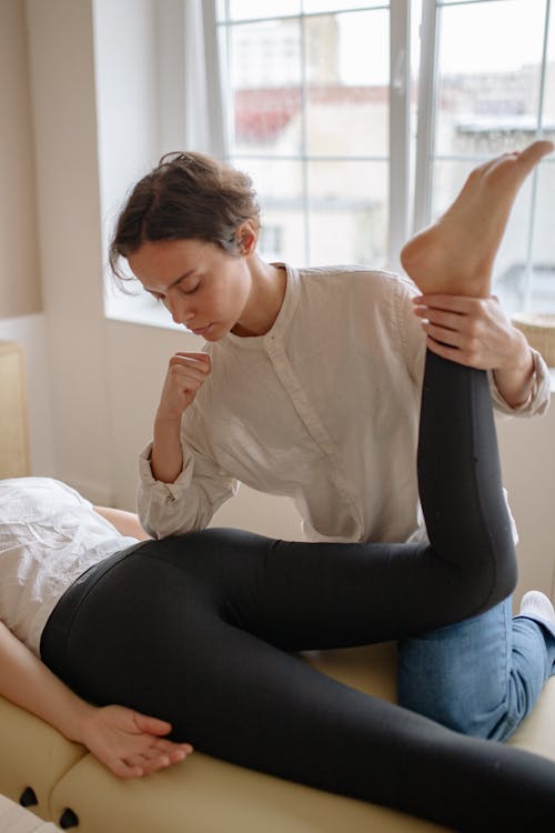 Free Woman Pressing Her Elbow on a Client's Buttocks Stock Photo