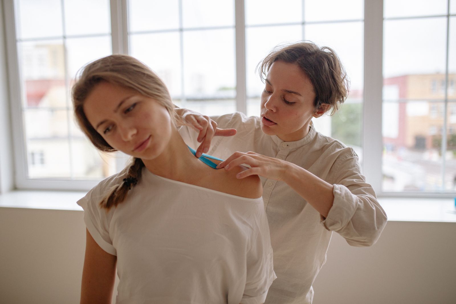 Bright indoor shoulder stretch showing upper back and collarbone posture