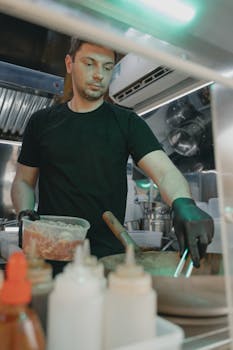 Chef preparing meal in a modern restaurant kitchen.