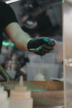 A chef's gloved hand carefully seasons food in a kitchen, showcasing culinary expertise.
