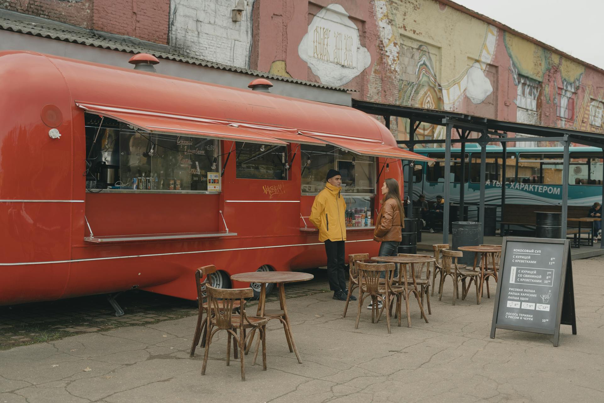 Street food truck with customers enjoying urban alfresco dining outdoors.