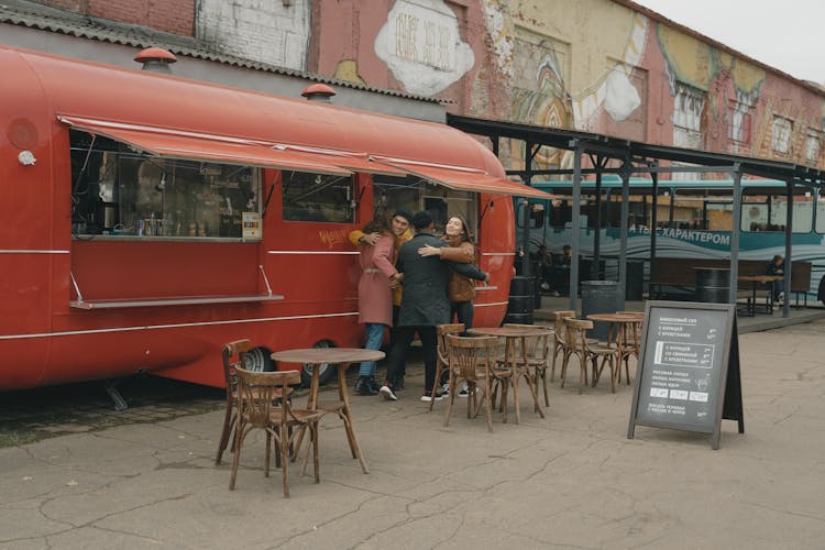 People Greeting Each Other Near A Food Truck