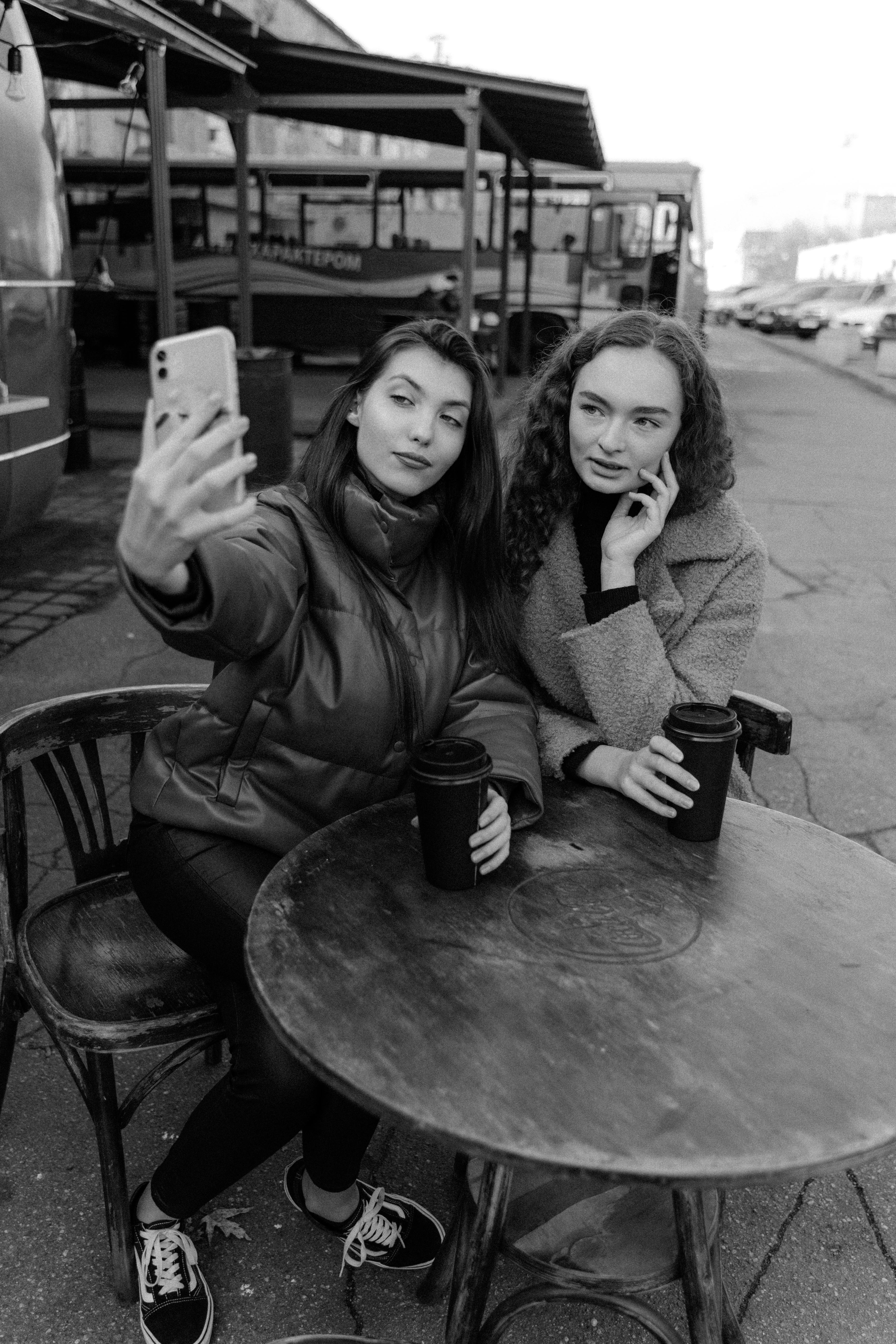 Grayscale Photo of 2 Women Sitting on Chair