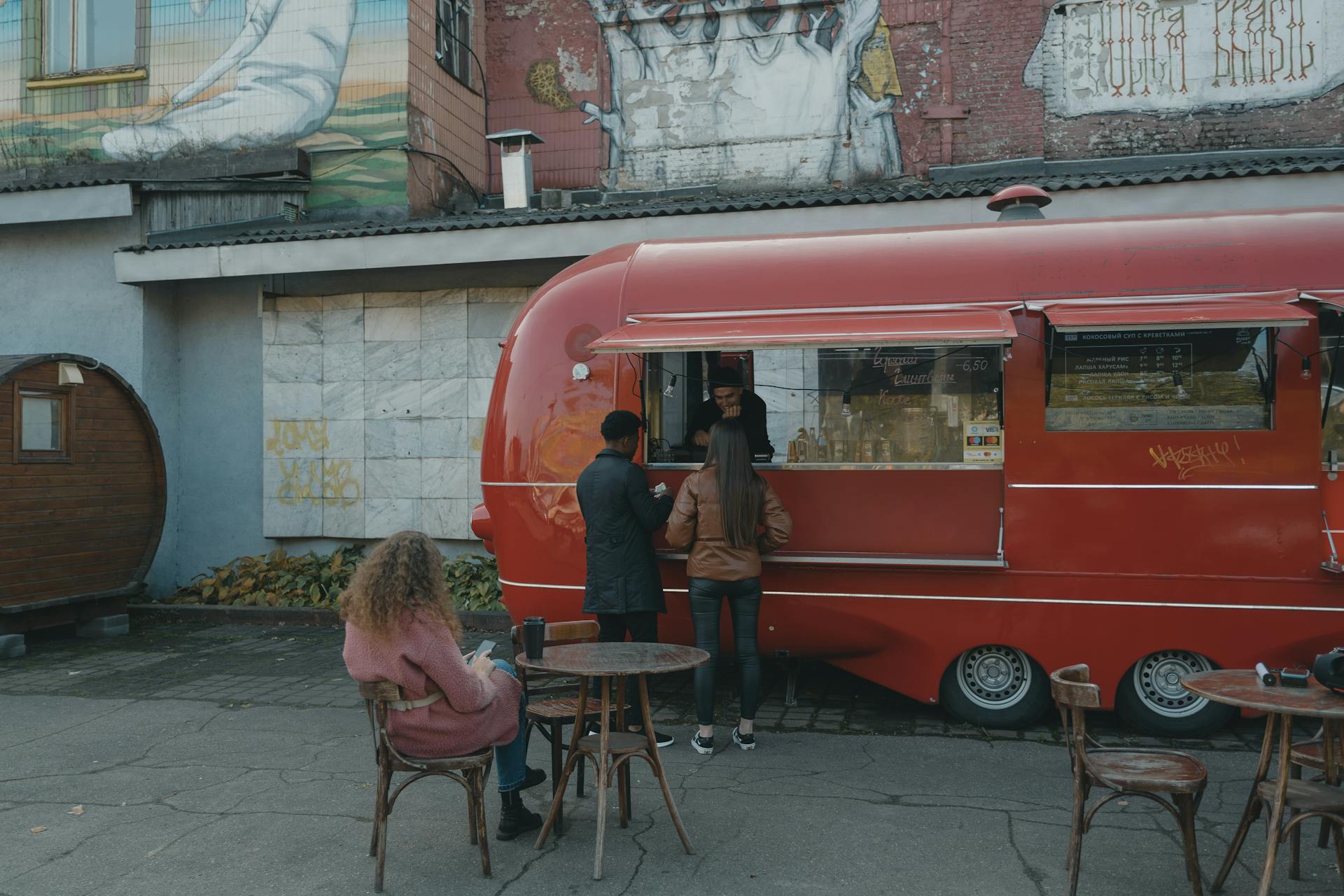 Woman in Brown Coat Standing Beside Red Van