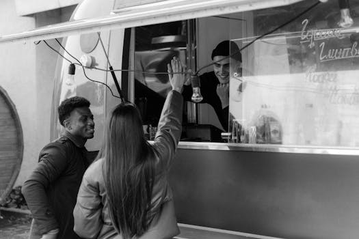 A vibrant street scene with friends high-fiving at a food truck.