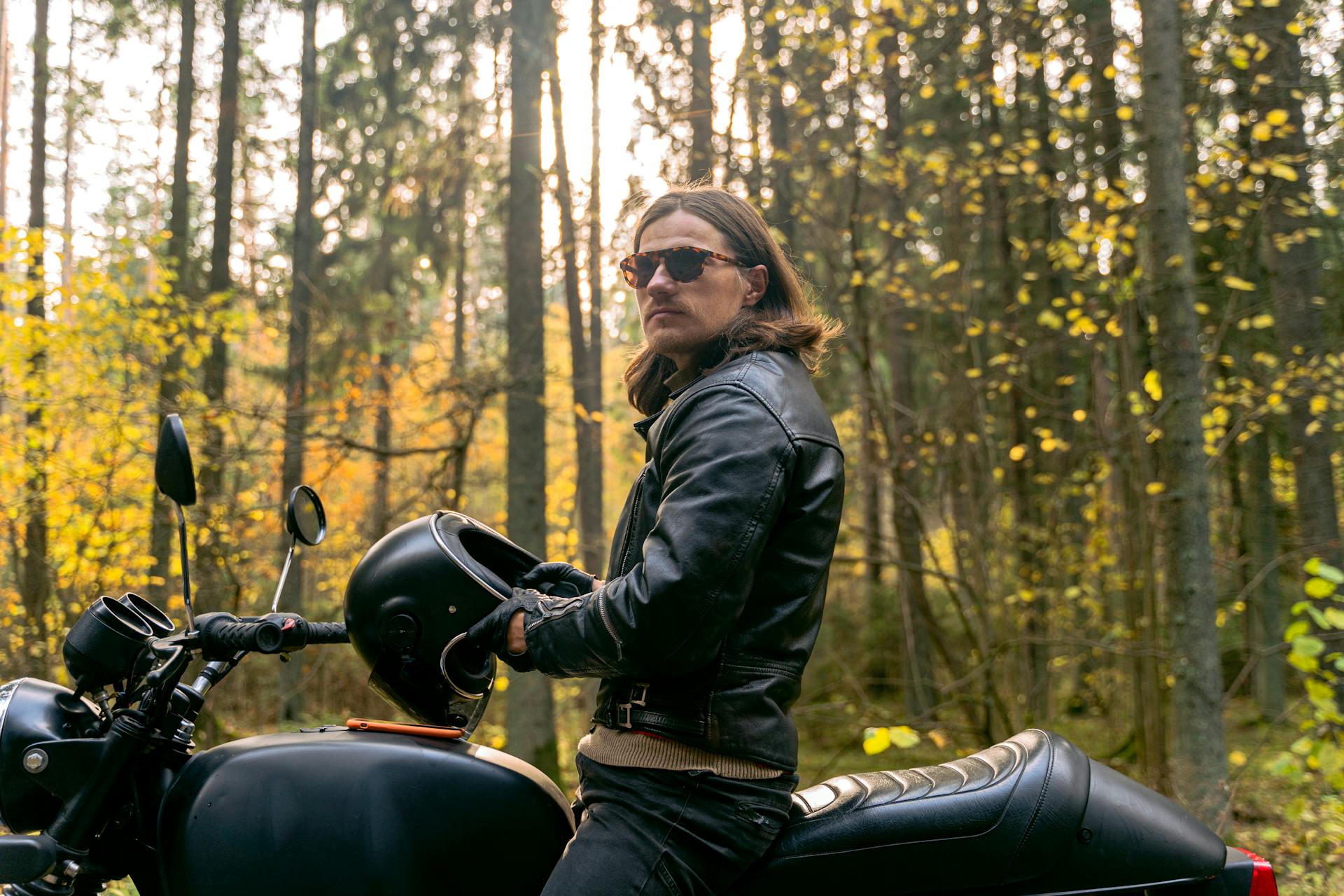 A Man in Black Leather Jacket Riding a Motorcycle