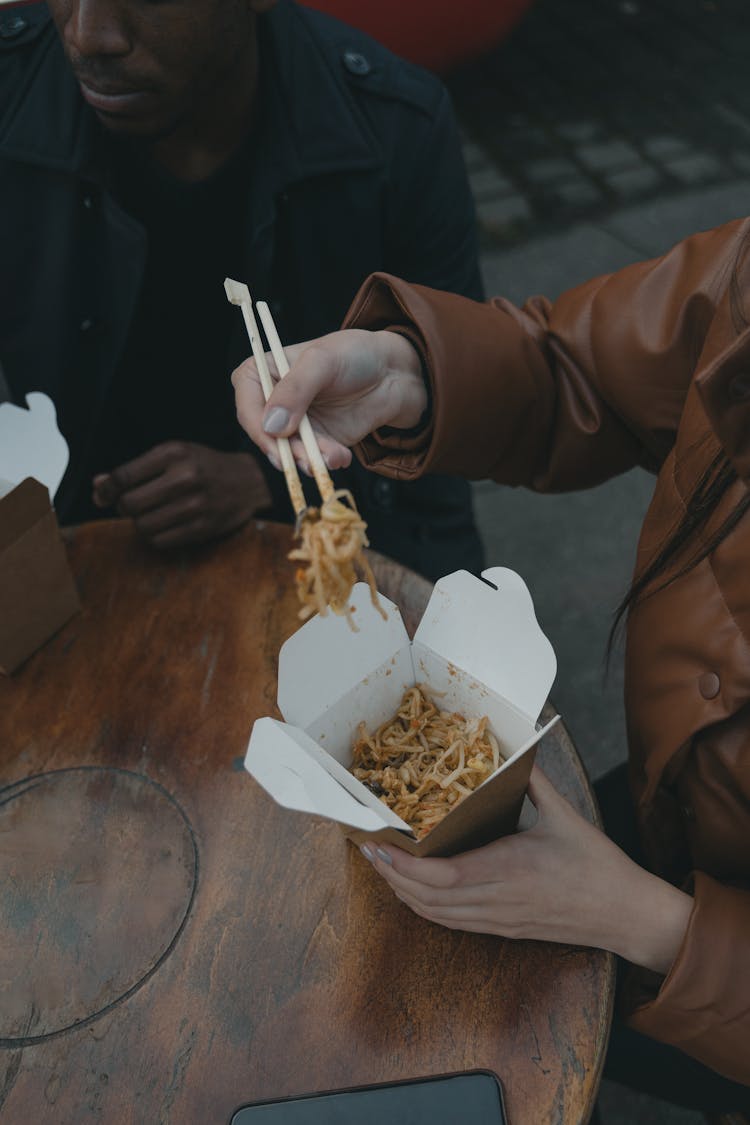 A Person In Brown Jacket Holding Take Out Food