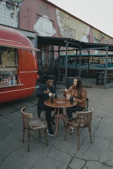 Couple enjoying a meal at an outdoor food truck with vibrant street art.