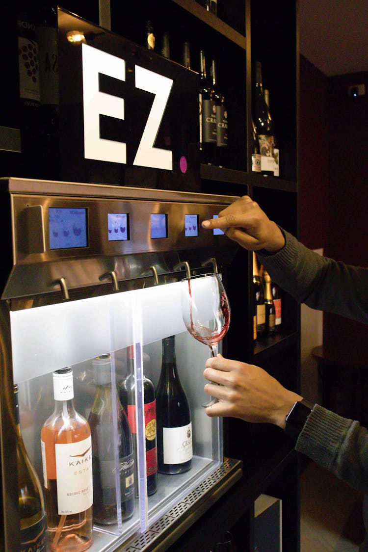 A Bartender Using A Wine Dispenser