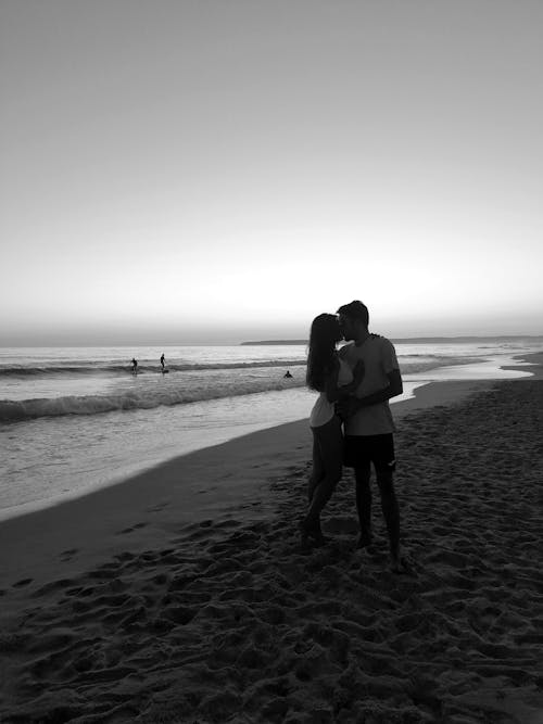 A Man and a Woman Kissing on the Beach