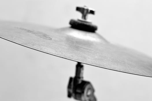 Detailed close-up of a metal cymbal from a drum set in monochrome.