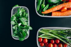 Organic vegetables displayed in plastic containers for a healthy diet.