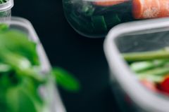 Close-up view of assorted fresh vegetables stored in plastic containers preserving freshness.