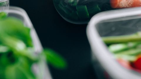 Close-up view of assorted fresh vegetables stored in plastic containers preserving freshness.