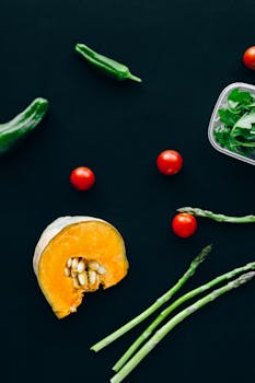 Fresh vegetables scattered on a black surface showcasing healthy eating options.