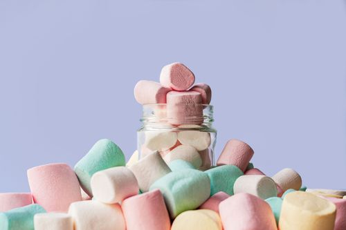 Free A vibrant collection of colorful marshmallows in a glass jar on a light background. Stock Photo