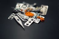 黑暗背景下的特写镜头中，有各种药丸和数字温度计