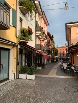 意大利拉齐斯风景如画的小巷里，设有户外用餐区，外墙色彩缤纷