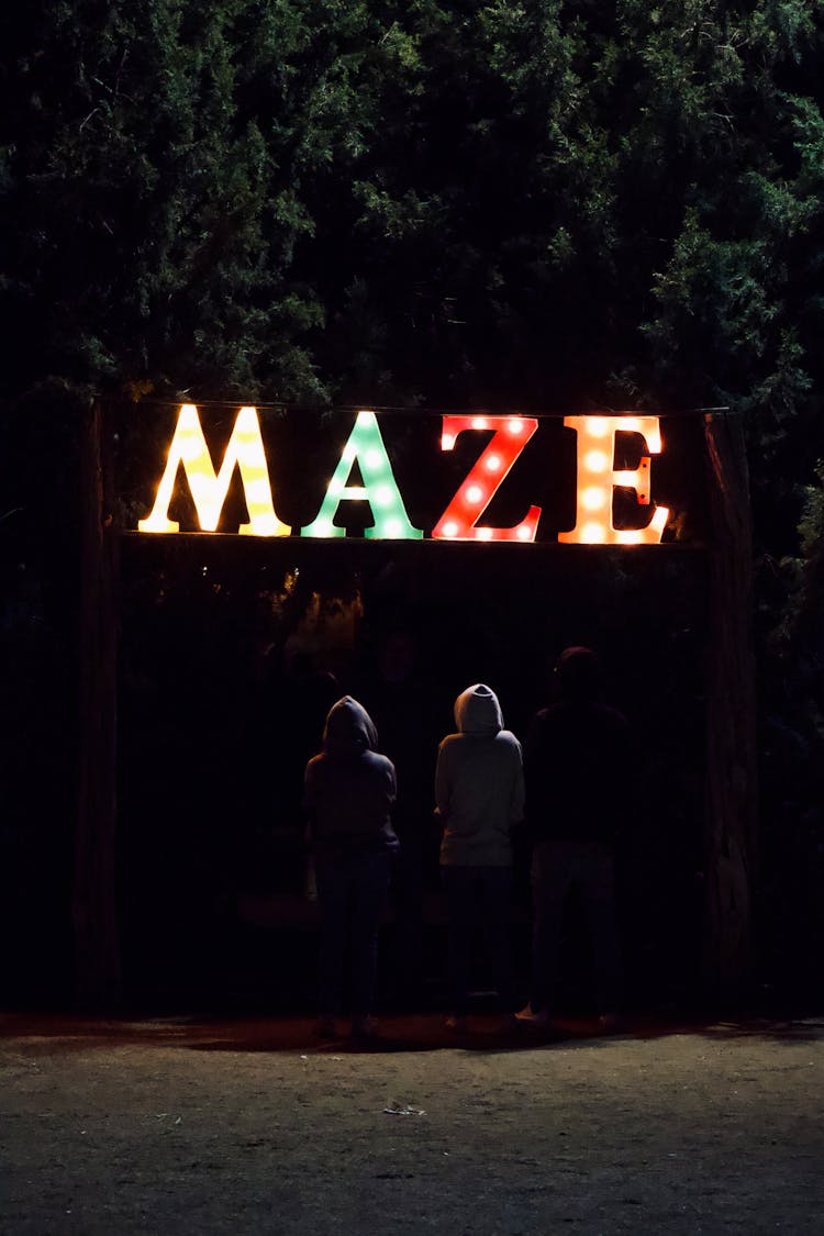 People Standing In Front Of A Lit Signage