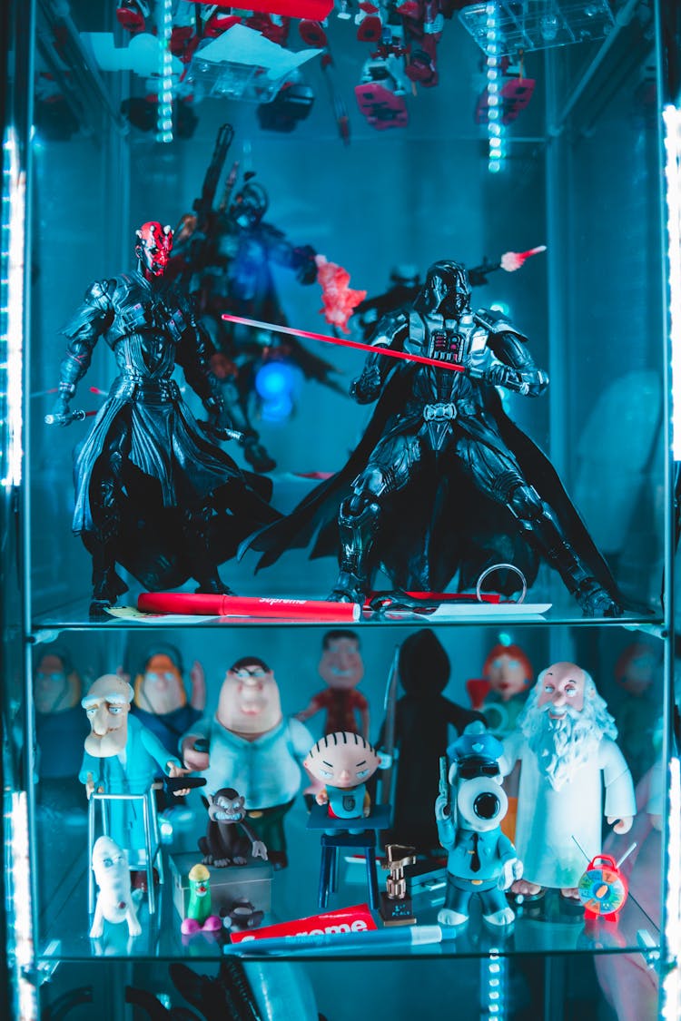 Collection Of Comic Figurines On Glass Shelves