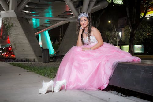 A Young Girl in a Dress Sitting on a Bench