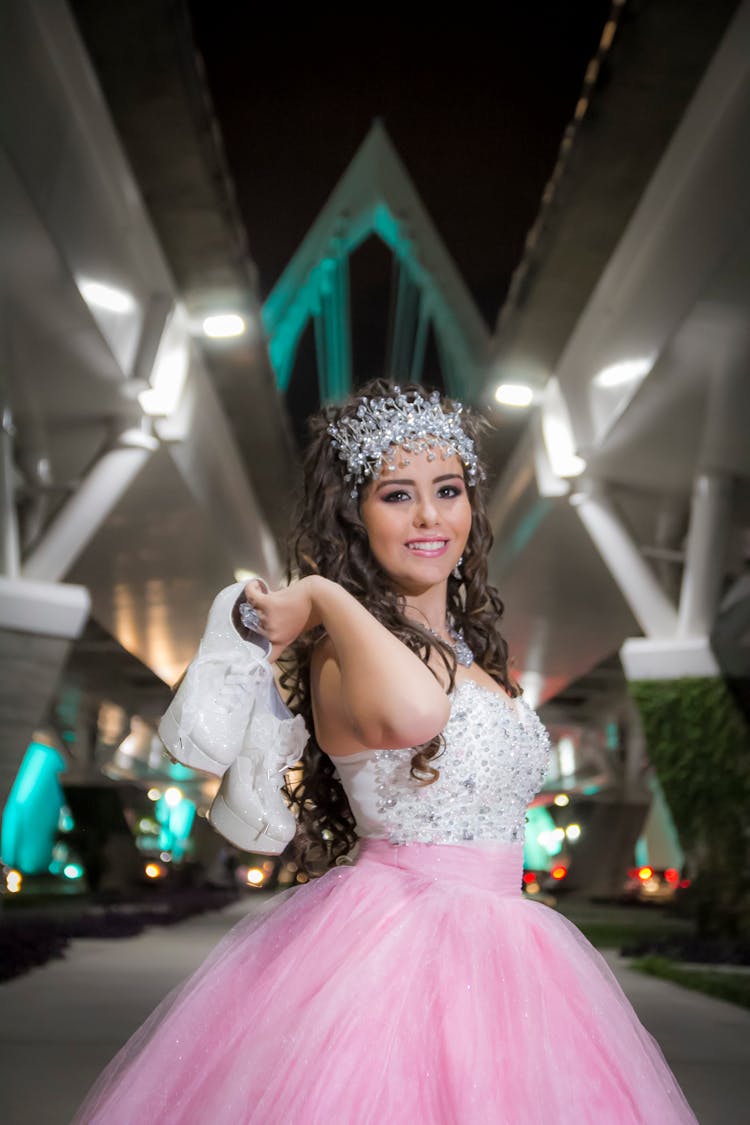 A Girl With A Crystal Headdress Carrying Her High Heels