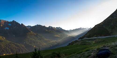 Foto profissional grátis de brilho do sol, garoa, montanhas