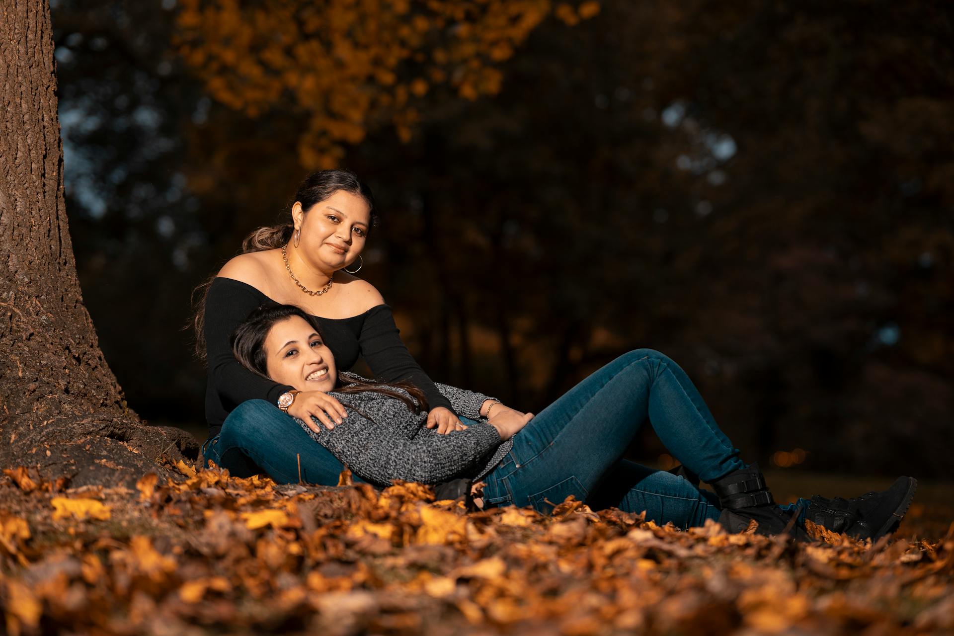 Two women enjoy a peaceful moment among autumn leaves in Glen Cove, NY.