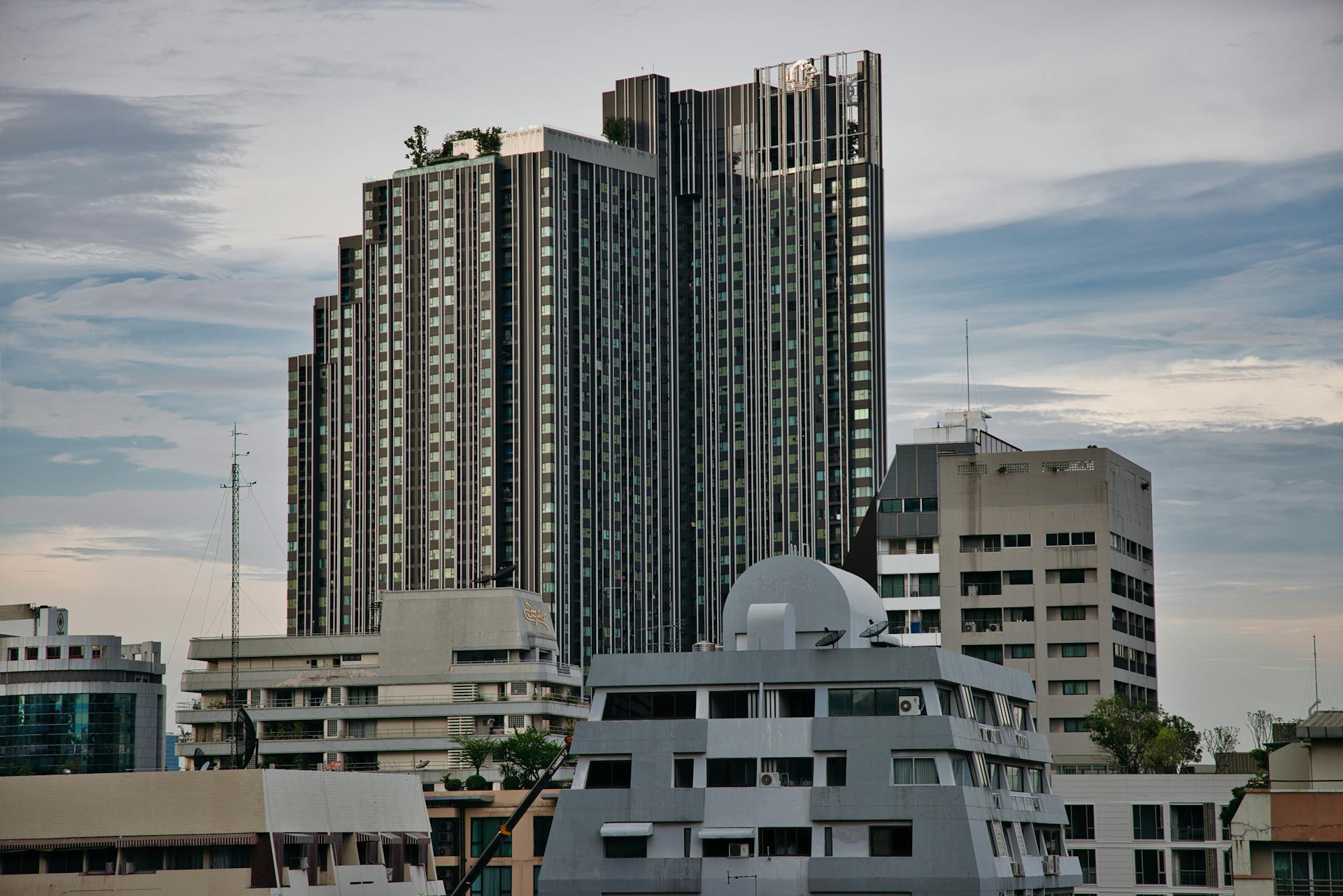 Skyline of modern high-rise buildings in Bangkok, Thailand with a moody sky.