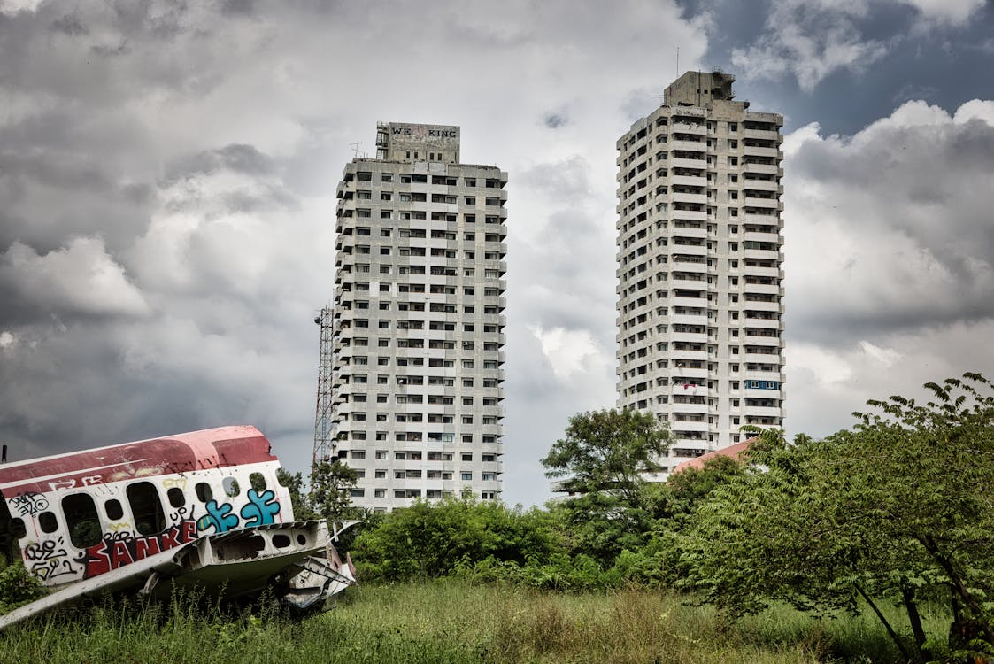 Free Wreckage on Green Grass Field Near High Rise Buildings Stock Photo