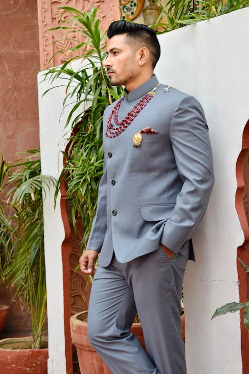 Man in Gray Suit Standing Beside Green Plant