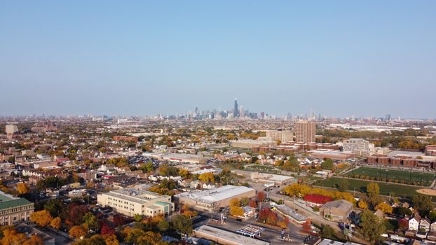 Aerial shot capturing the Chicago skyline with sprawling suburbs and fall foliage.