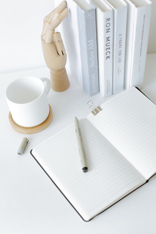 Notebook opened on desk near books