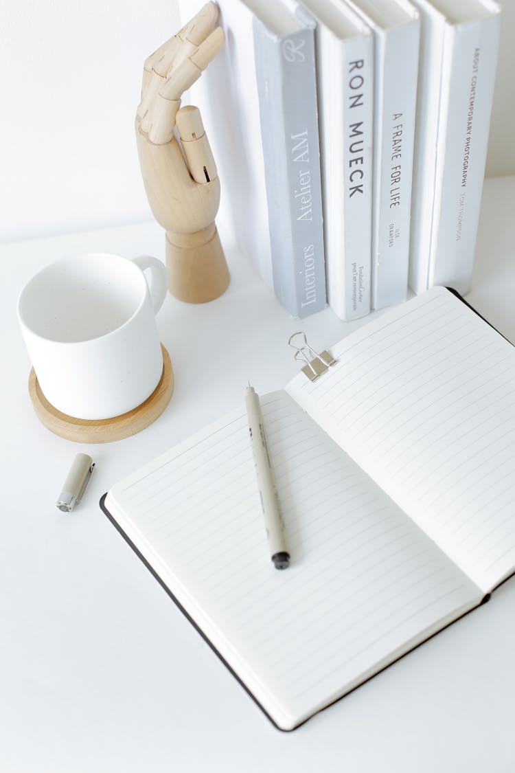 Notebook Opened On Desk Near Books