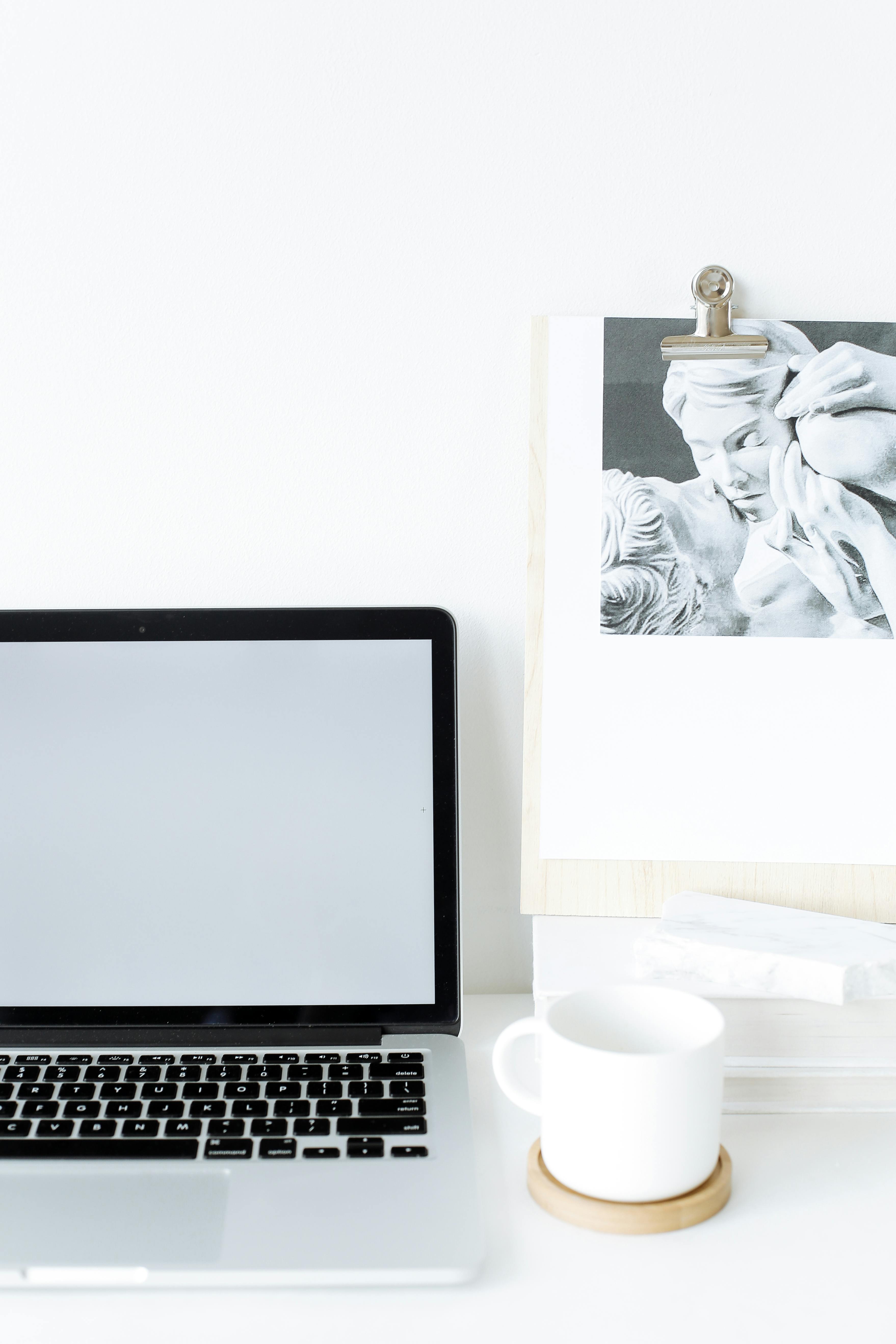 modern opened laptop on desk near cup