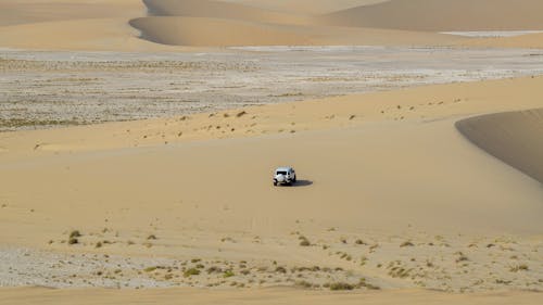 Off road vehicle driving in sandy desert