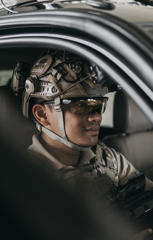 Free Man Wearing Military Protective Gears Sitting Inside A Vehicle Stock Photo