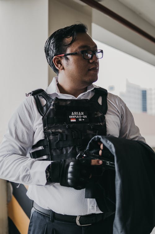 Man in White Dress Shirt With Vest Holding A Gun