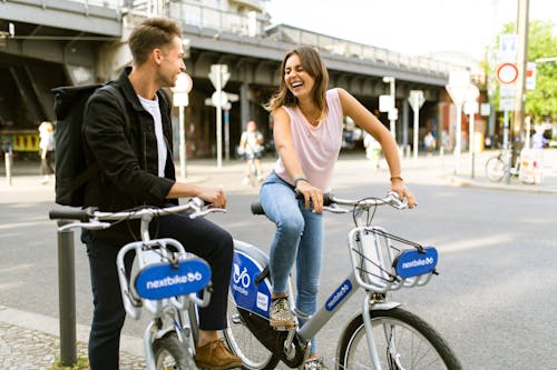 Free A Happy Man and a Woman Riding Bikes Stock Photo