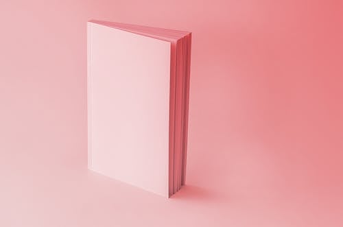 Close-Up Shot of a Pink Notebook on a Pink Surface