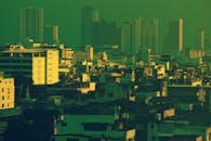 黎明时分，曼谷的天际线呈现出戏剧性的景观，高楼林立，色调以绿色为主