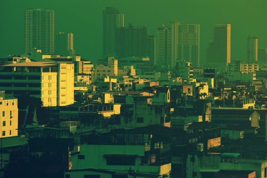 黎明时分，曼谷的天际线呈现出戏剧性的景观，高楼林立，色调以绿色为主