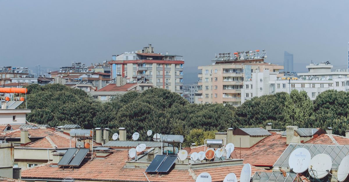 Städtische Dachlandschaft mit Solarpanelen und Satellitenschüsseln aus der Vogelperspektive