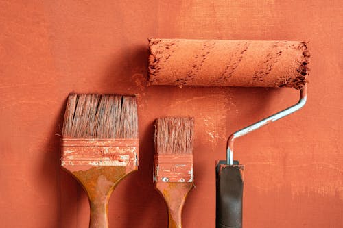 Close-Up Shot of Variety of Paintbrushes with Brown Paint