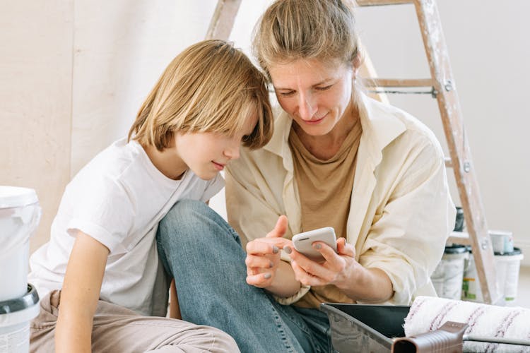 Mother And Son Looking At The Smartphone