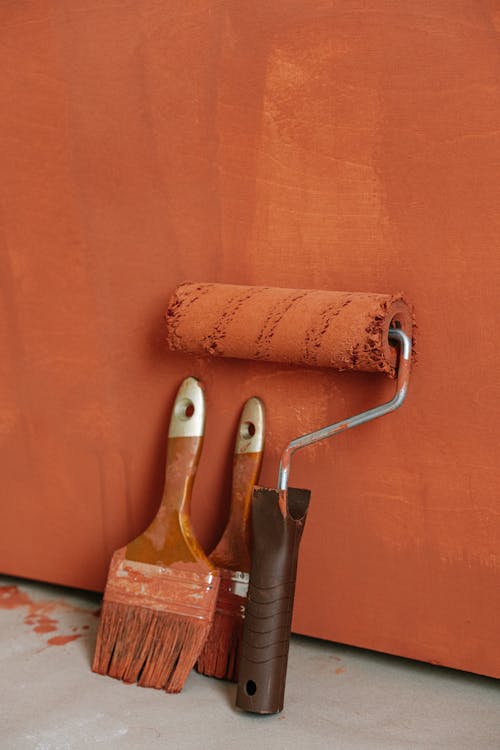Free Paintbrushes and a Paint Roller Covered in Paint Stock Photo