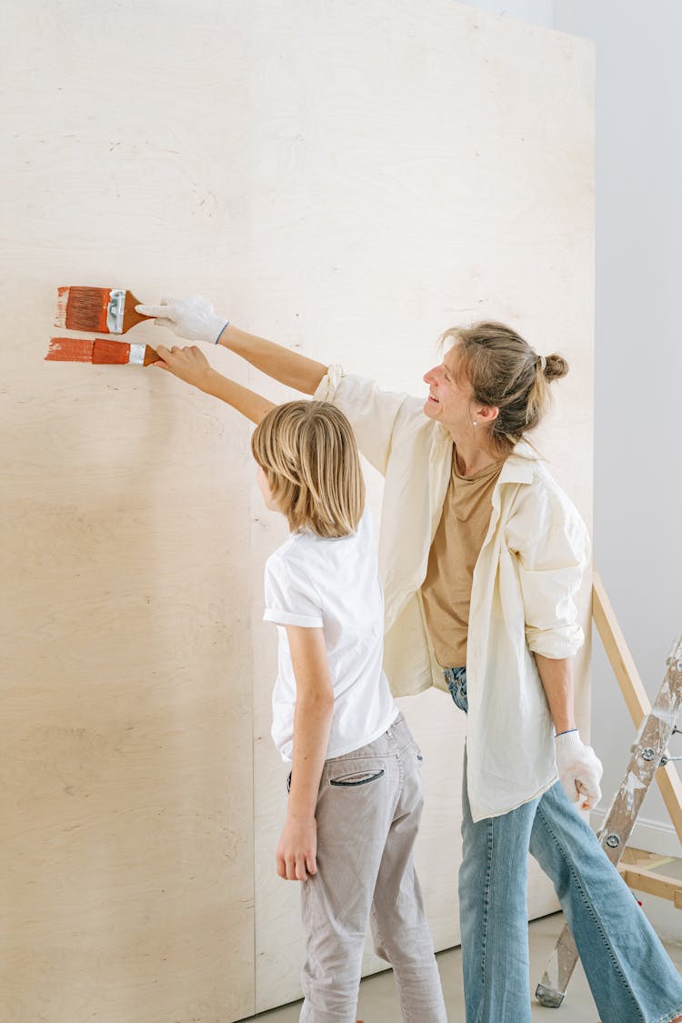 A Mother And Son Painting A Wall